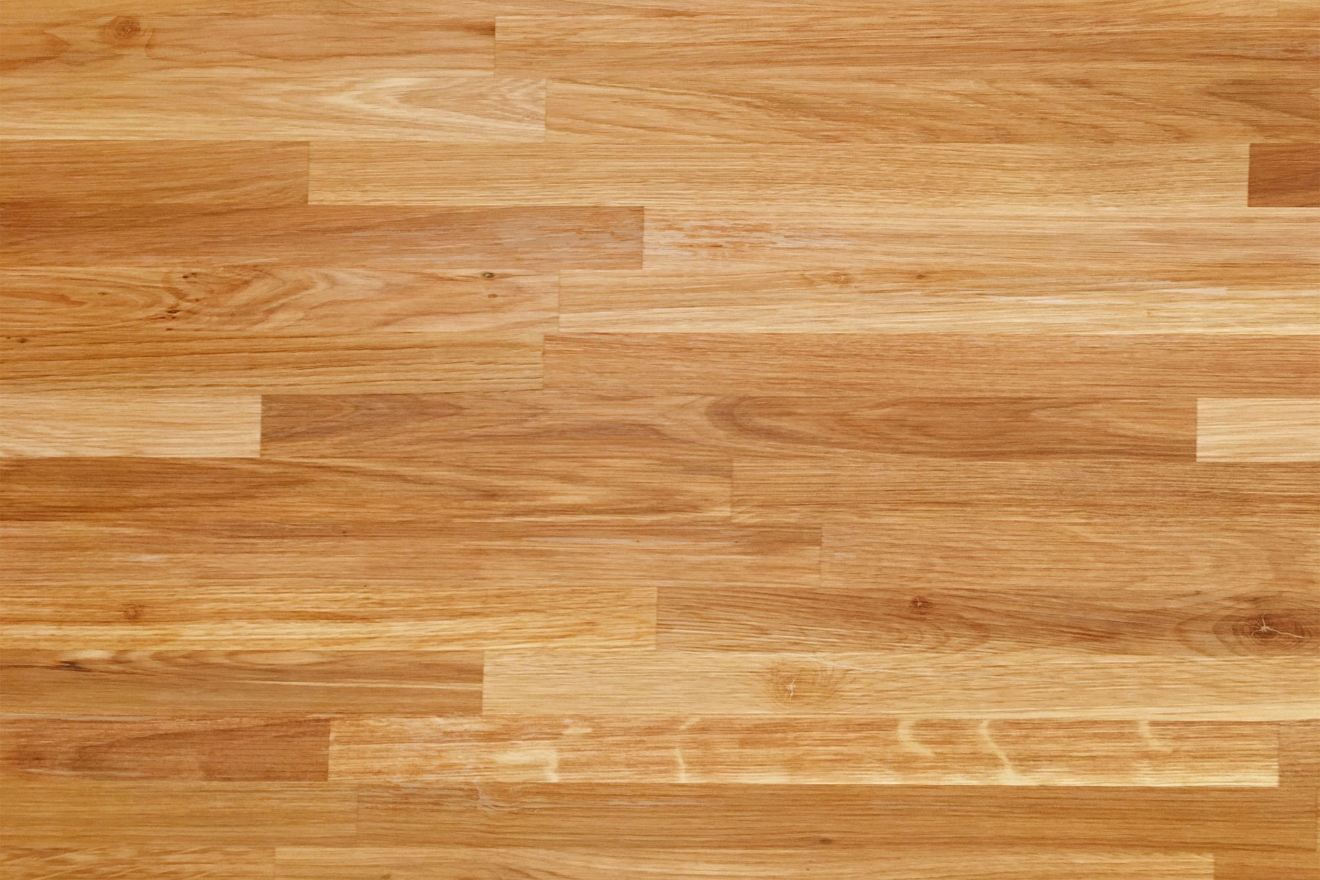 Wood floor with a light brown hue, consisting of rectangular planks.