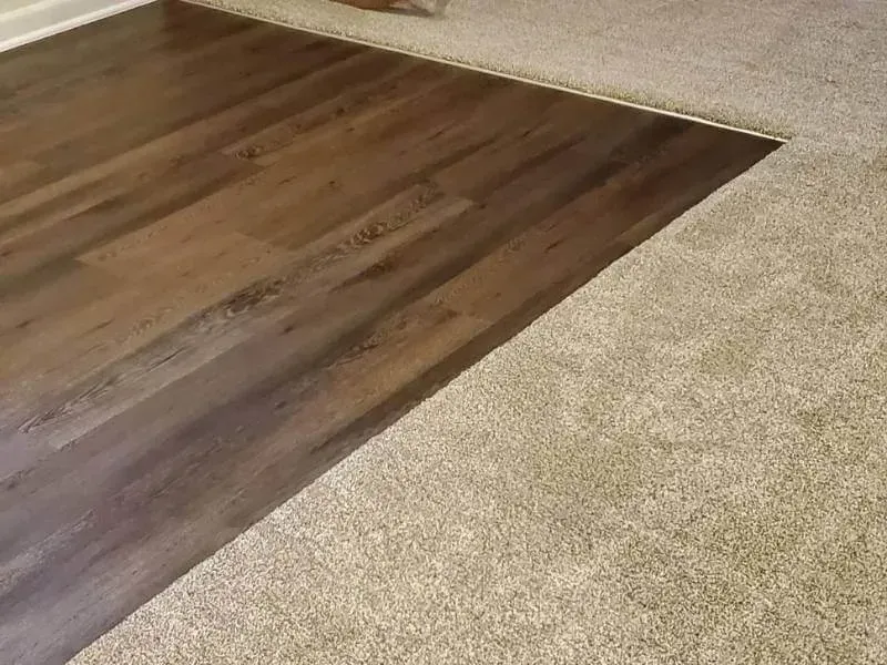 Shiny hardwood floors in a living room with olive green walls and a large framed artwork.