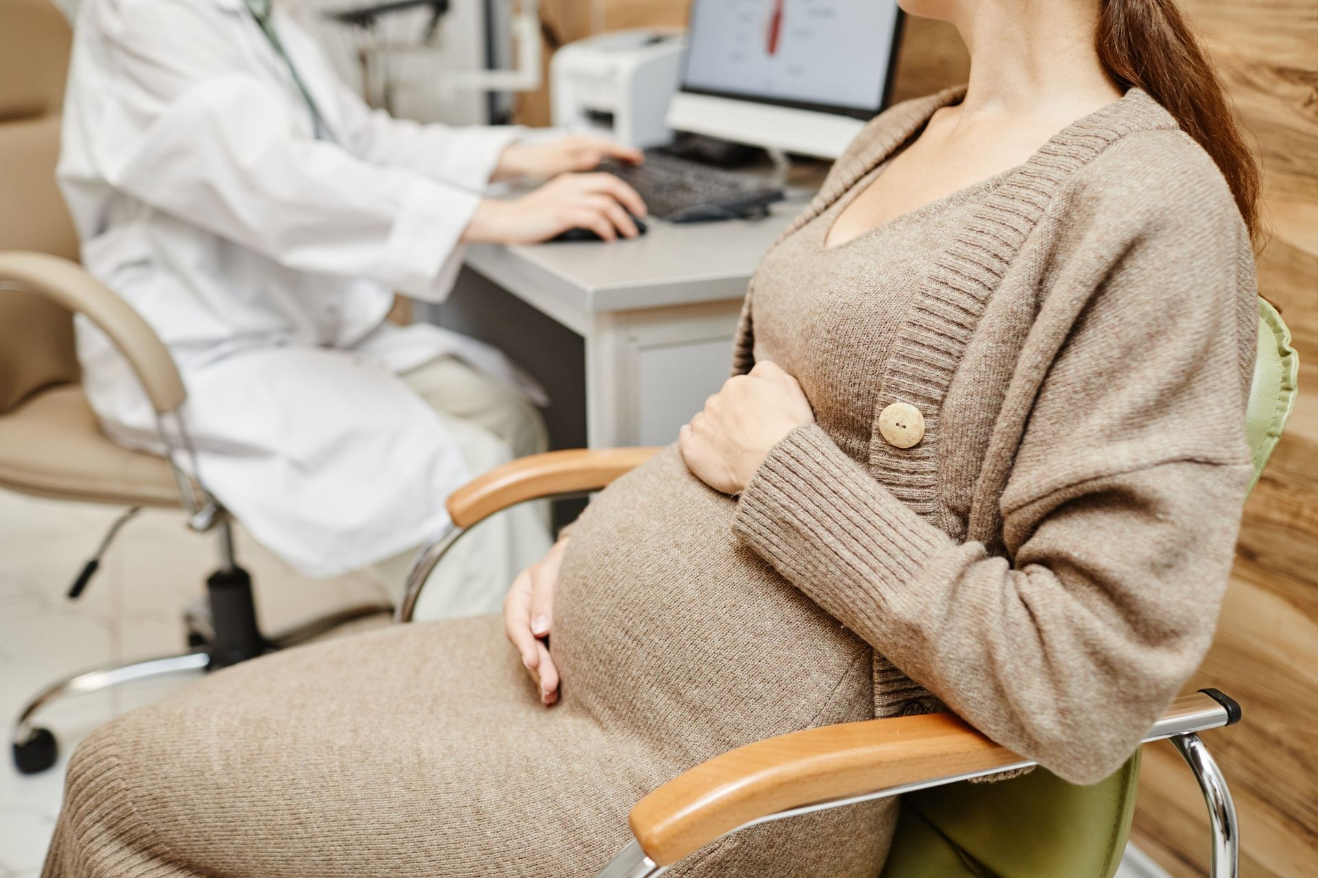 Pregnant woman sitting in exam room awaiting prenatal care at Clinica Santa Maria OBGYN in Brownsville, TX.