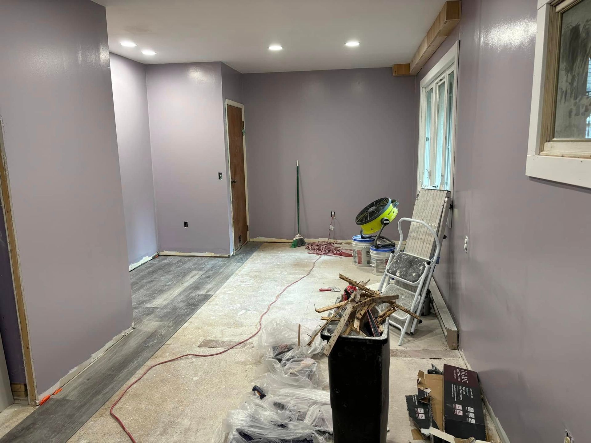 A room with purple walls and a chair in it.