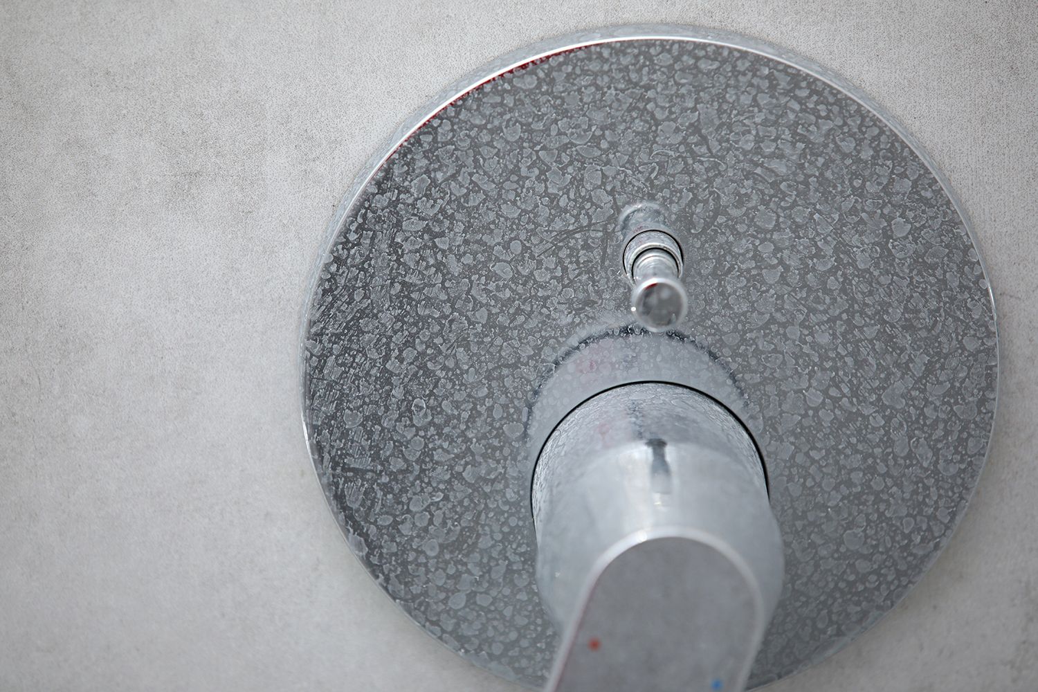 A close up of a shower head on a wall.