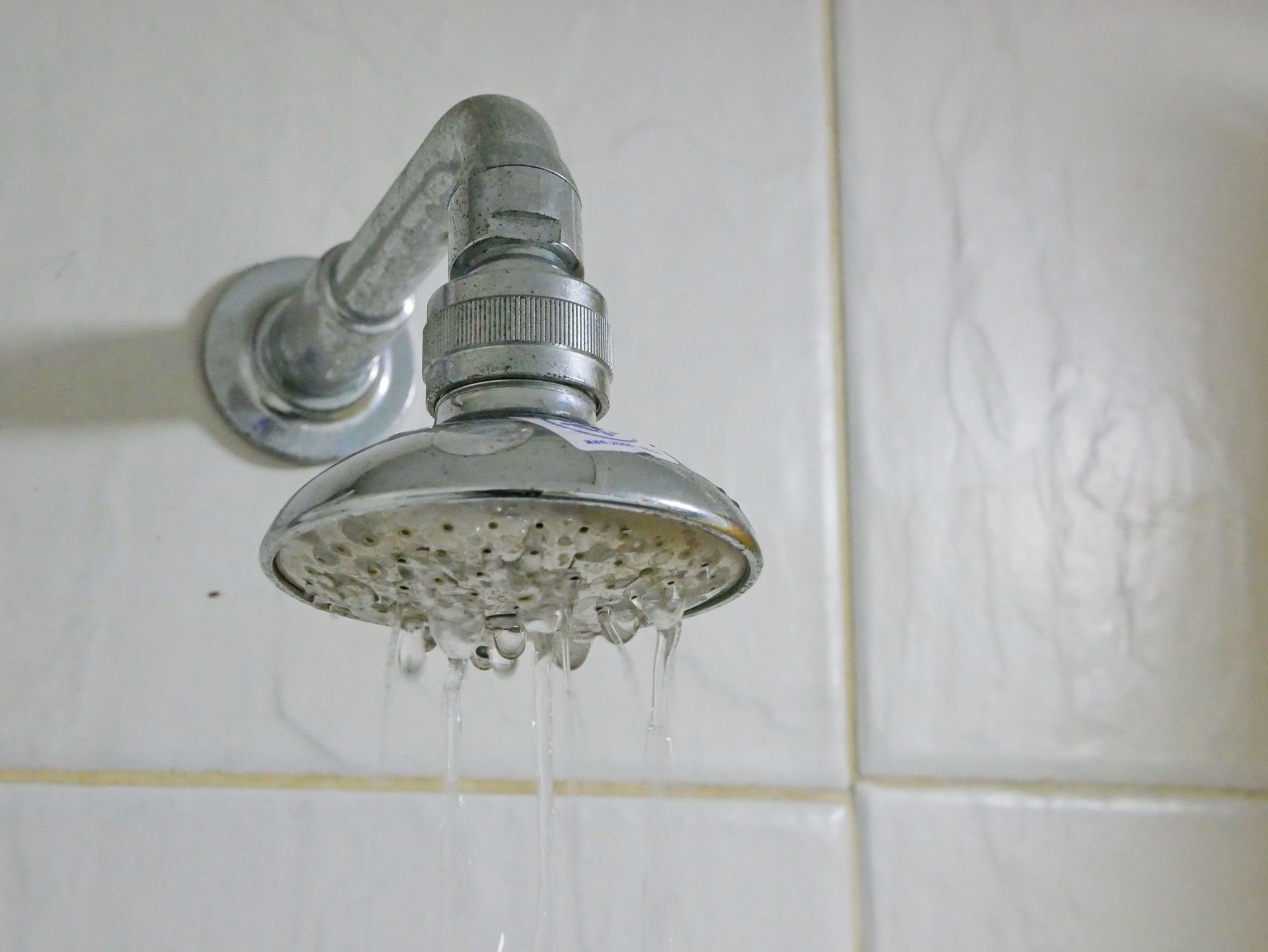 A close up of a shower head with water coming out of it
