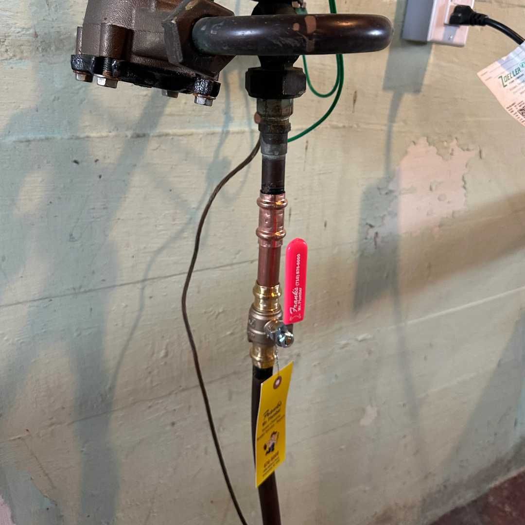 A copper pipe with a red valve attached to it