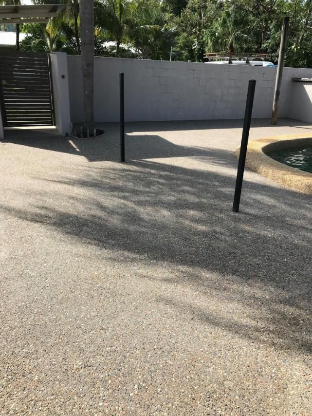A Concrete Driveway With a Pool in the Background — Tropical North Concreting In Trinity Park, QLD