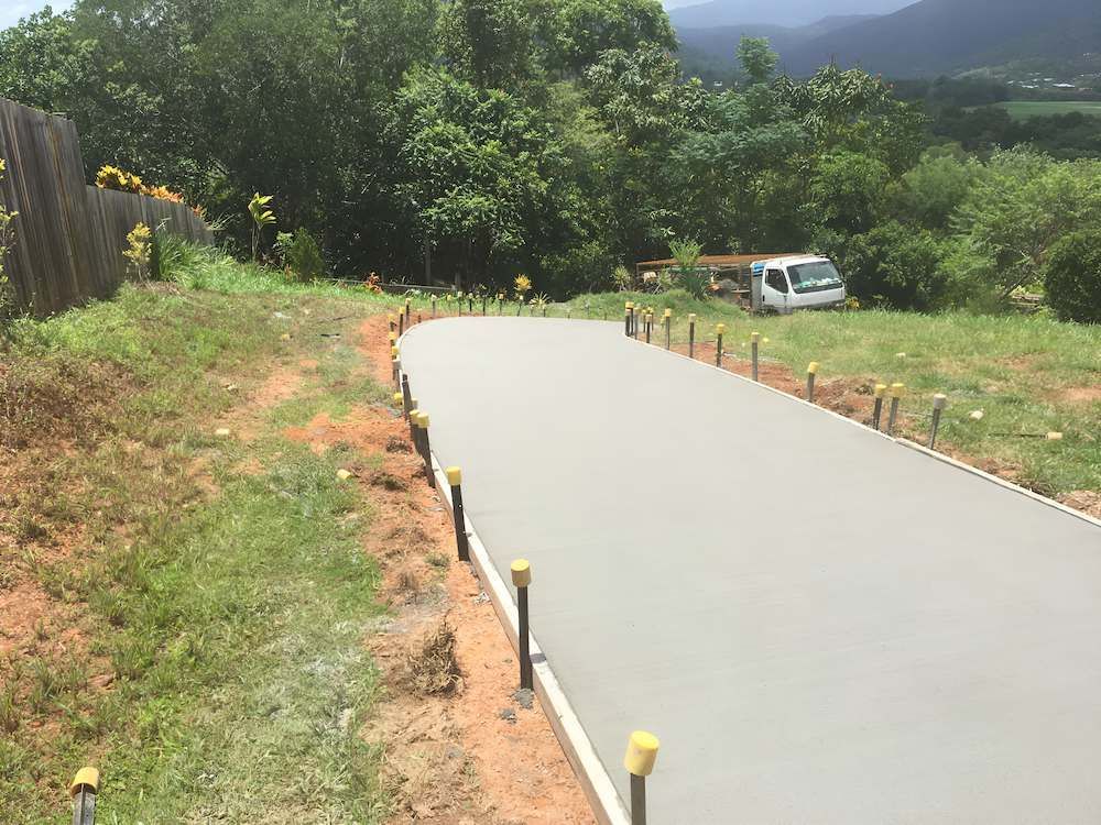 A Truck Is Parked On The Side Of A Road Next To A Fence — Tropical North Concreting In Trinity Park, QLD