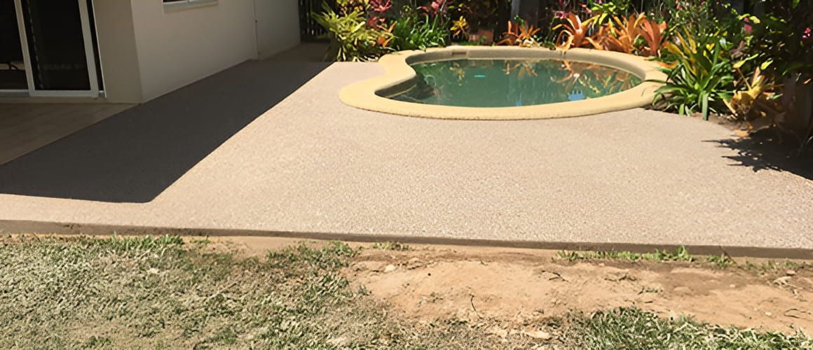 There Is A Swimming Pool In The Backyard Of A House — Tropical North Concreting In Trinity Park, QLD