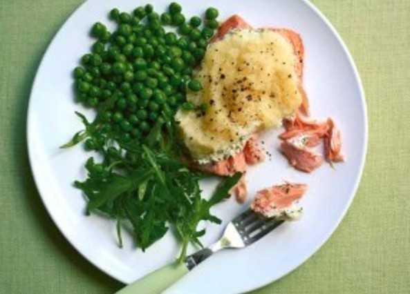 Plate with baked salmon, peas, and greens; a fork with salmon visible.