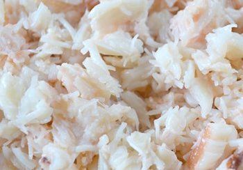 Shredded, cooked crab meat, light and flaky with hints of pink.