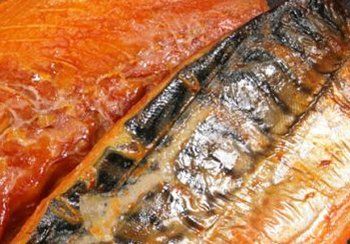 Smoked fish fillets, featuring orange-brown flesh and dark skin, close-up.