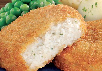 Breaded rice cake with a visible interior, served with peas and a potato.