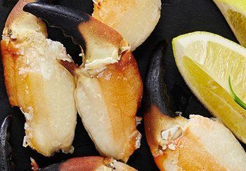 Cooked crab claws with a lemon wedge.