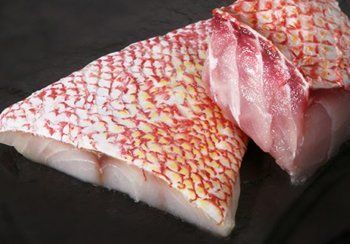 Raw red snapper fillets with red and white patterned skin.
