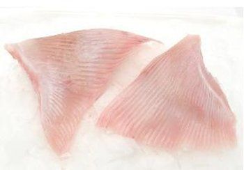 Two raw, pink skate wings on a white surface, showing a textured, fan-like structure.