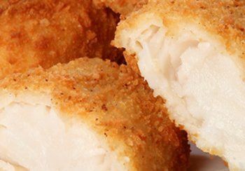 Fried fish, close-up showing flaky, white fish inside golden, crispy breading.