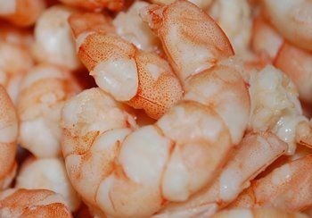 Cooked shrimp, pink and white, close-up, piled together.