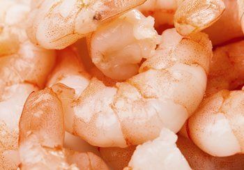 Cooked shrimp, close-up, pink and white flesh, curled bodies.
