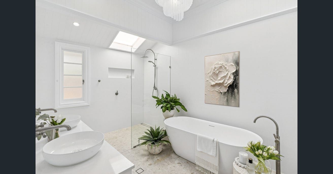 White bathroom with a freestanding tub, glass shower, and plants. — Caprice Cabinets in Coolum Beach, QLD