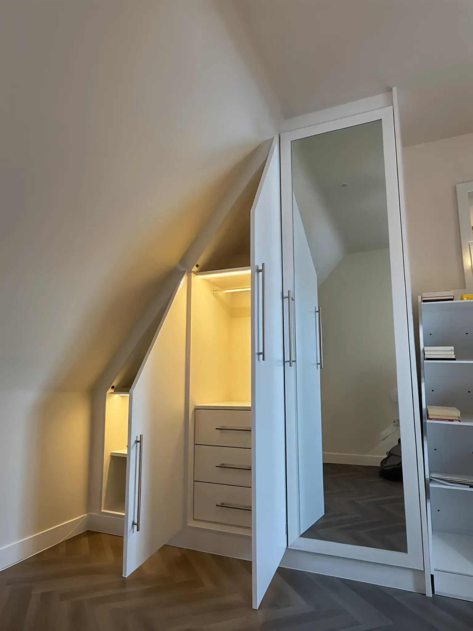 White closet built into an angled ceiling, with drawers, lighting, and a full-length mirror. — Caprice Cabinets in Caloundra, QLD