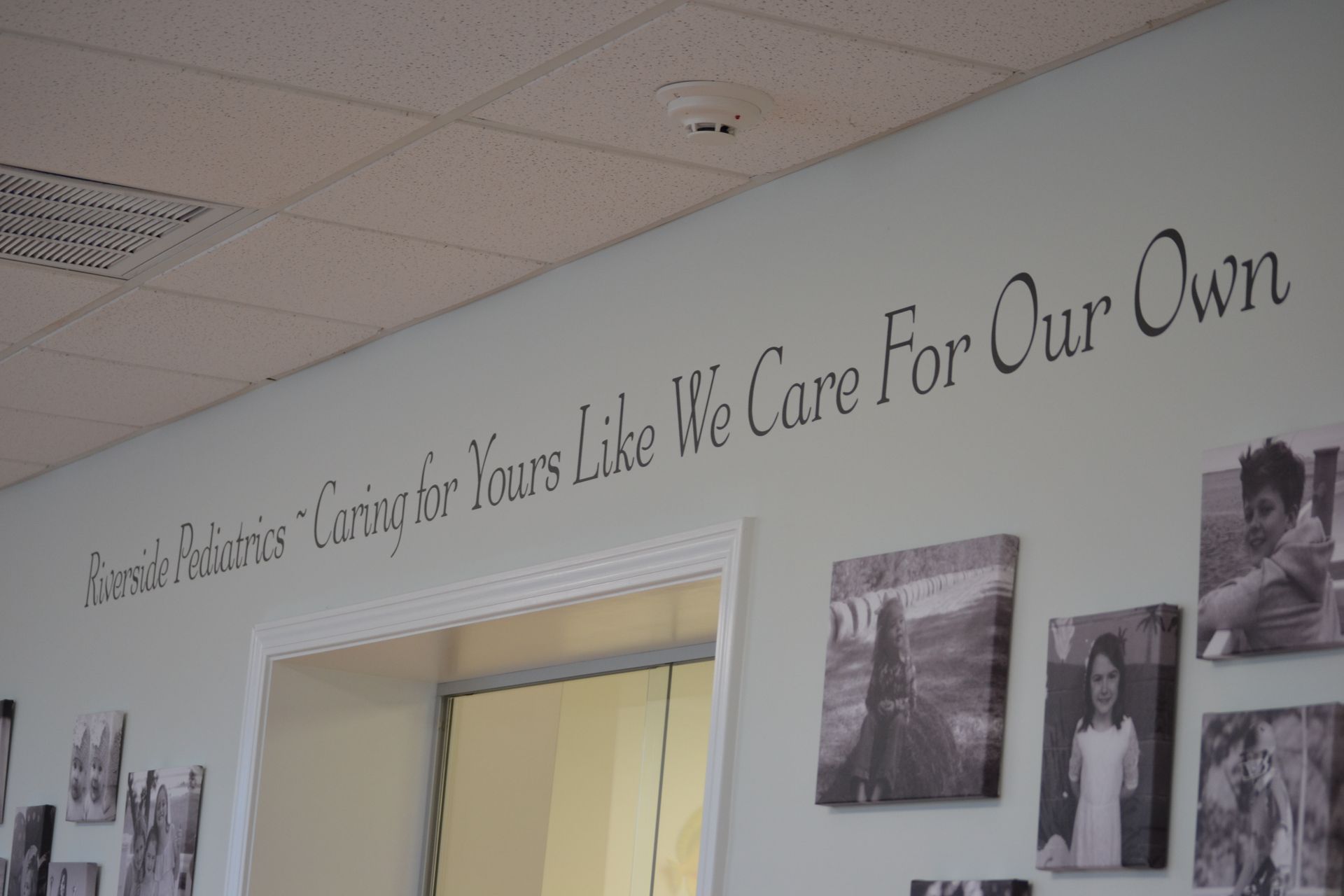 A sign on a wall that says we care for our own at Riverside Pediatrics.