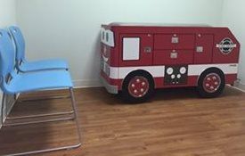 A toy fire truck in the corner of the room at Riverside Pediatrics.