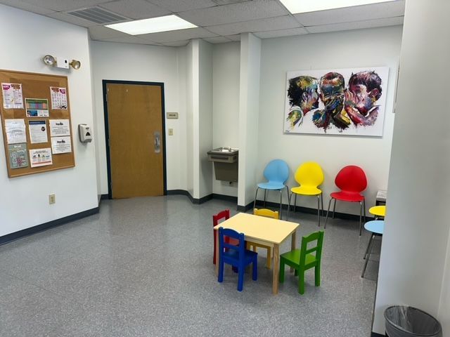 A children 's waiting room with a table and chairs at Riverside Pediatrics.