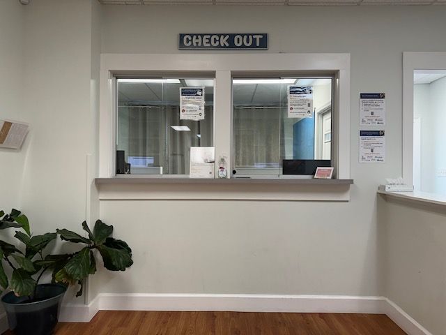 A check out counter with a plant in front of it at Riverside Pediatrics.