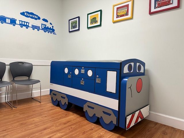 A blue and white train shaped cabinet in a waiting room at Riverside Pediatrics.