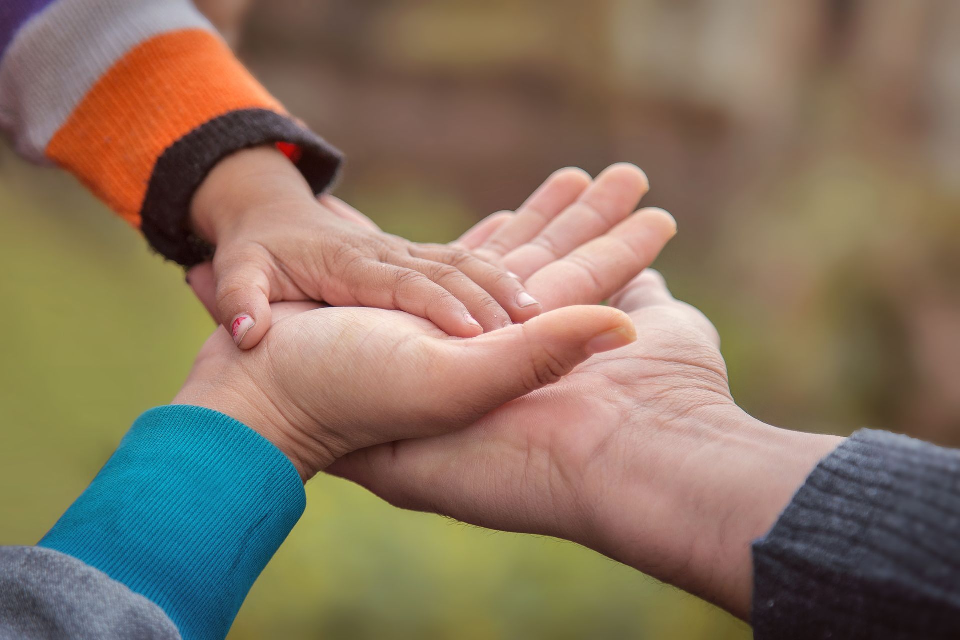 A person is holding a child 's hand in their palm.