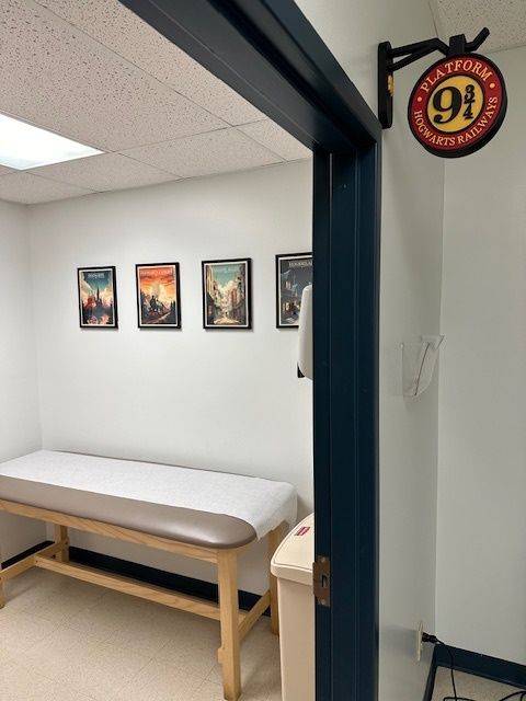 A room with a bed and a sign that says platform 9 at Riverside Pediatrics.