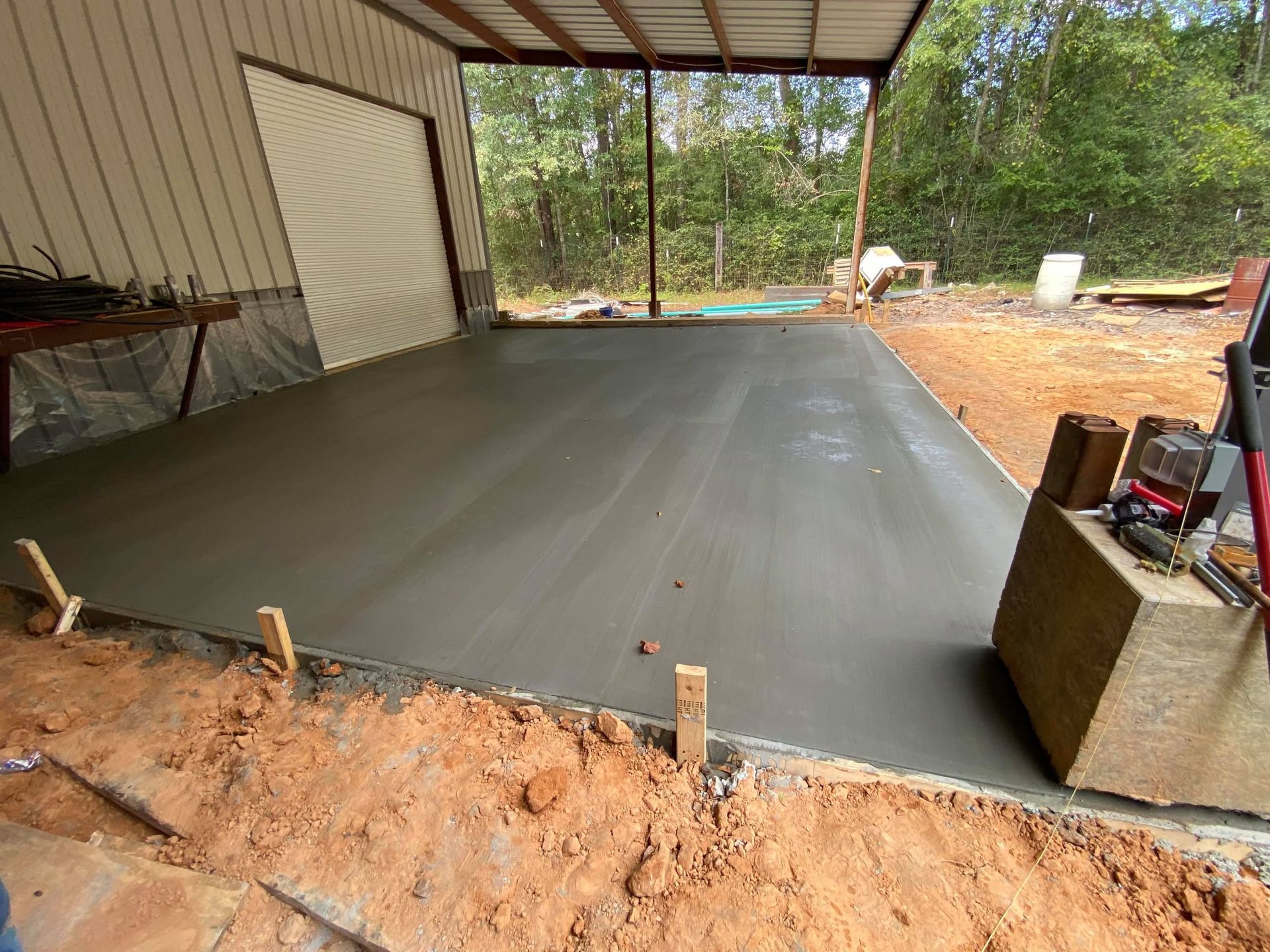 A concrete floor is being poured in front of a building.