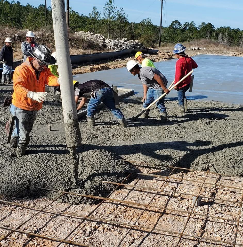 A group of construction workers are working on a concrete floor