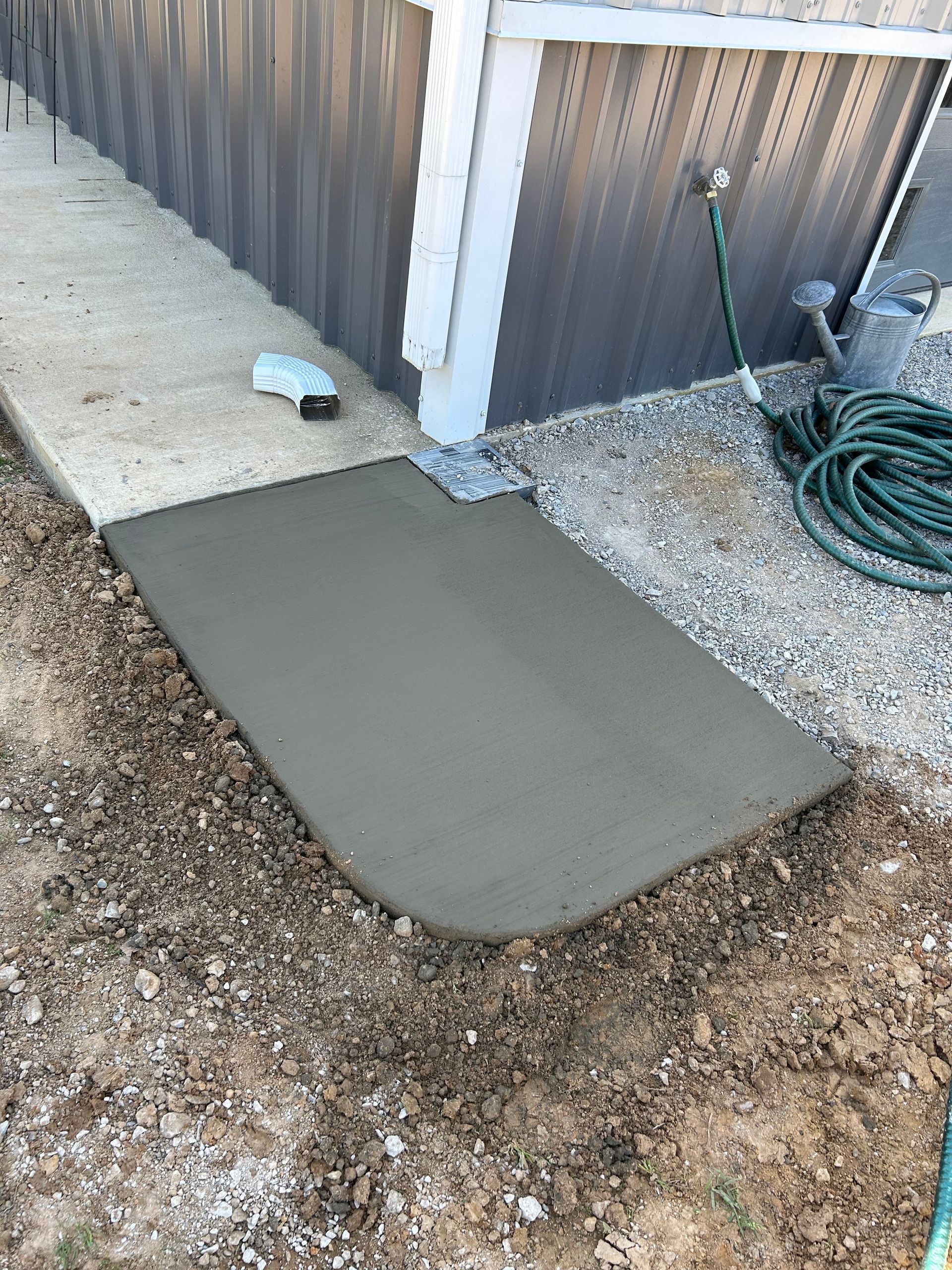 A concrete walkway is being built next to a house.