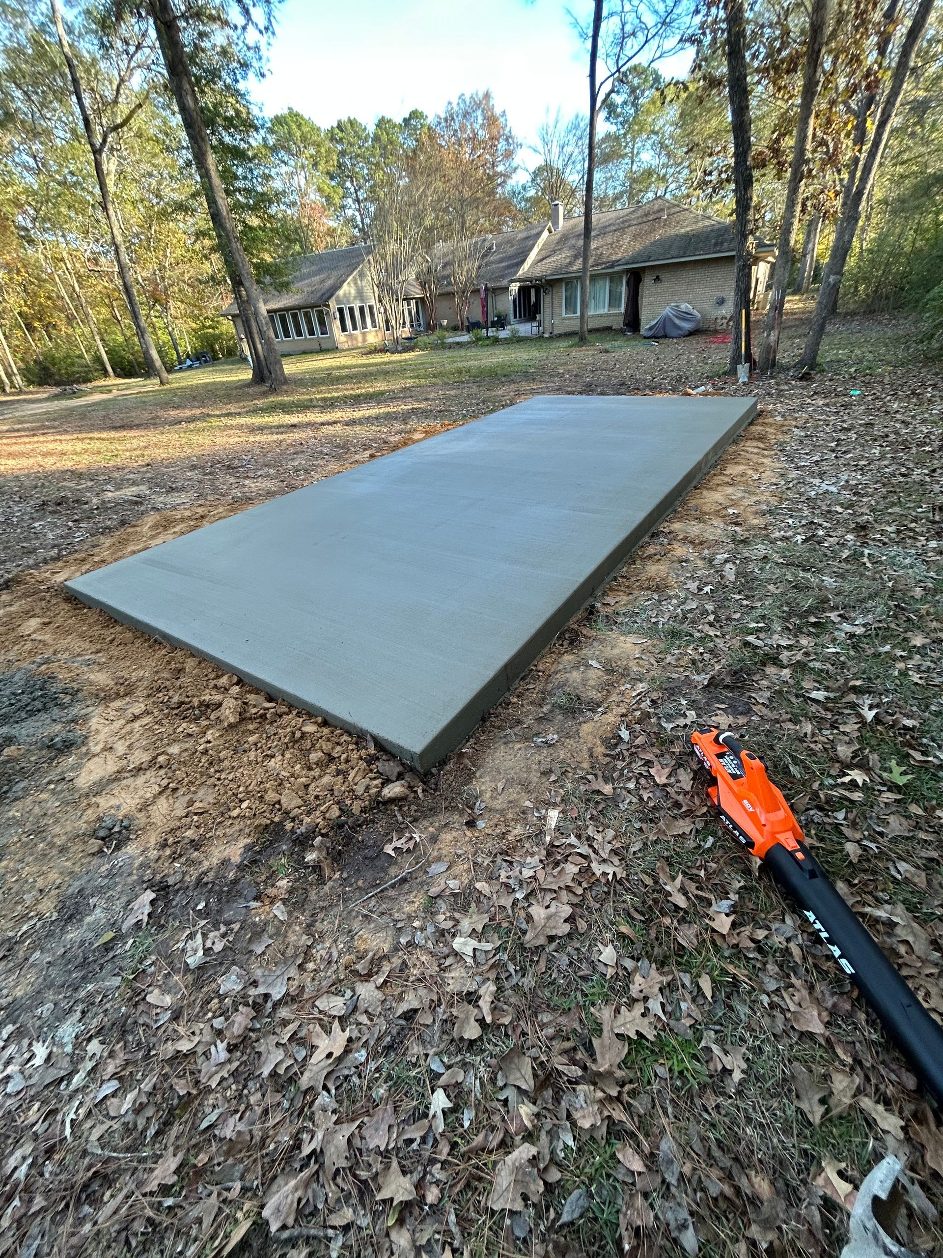 A concrete walkway is being built in front of a house.