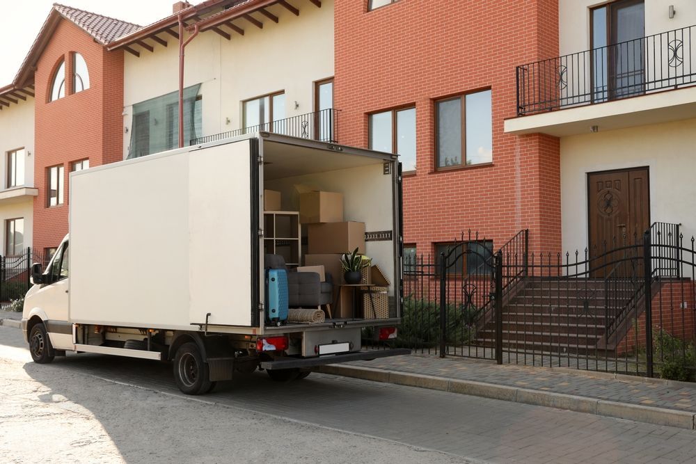 A Moving Truck Is Parked In Front Of A House — Easy Flow Removals In Laurieton, NSW