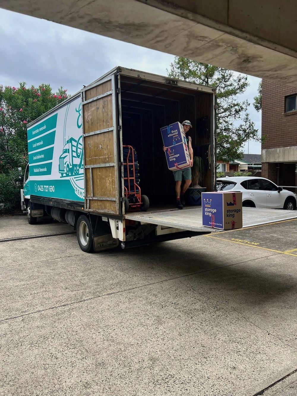 A Group Of People Are Standing In Front Of A Moving Truck — Easy Flow Removals In Port Macquarie, NSW
