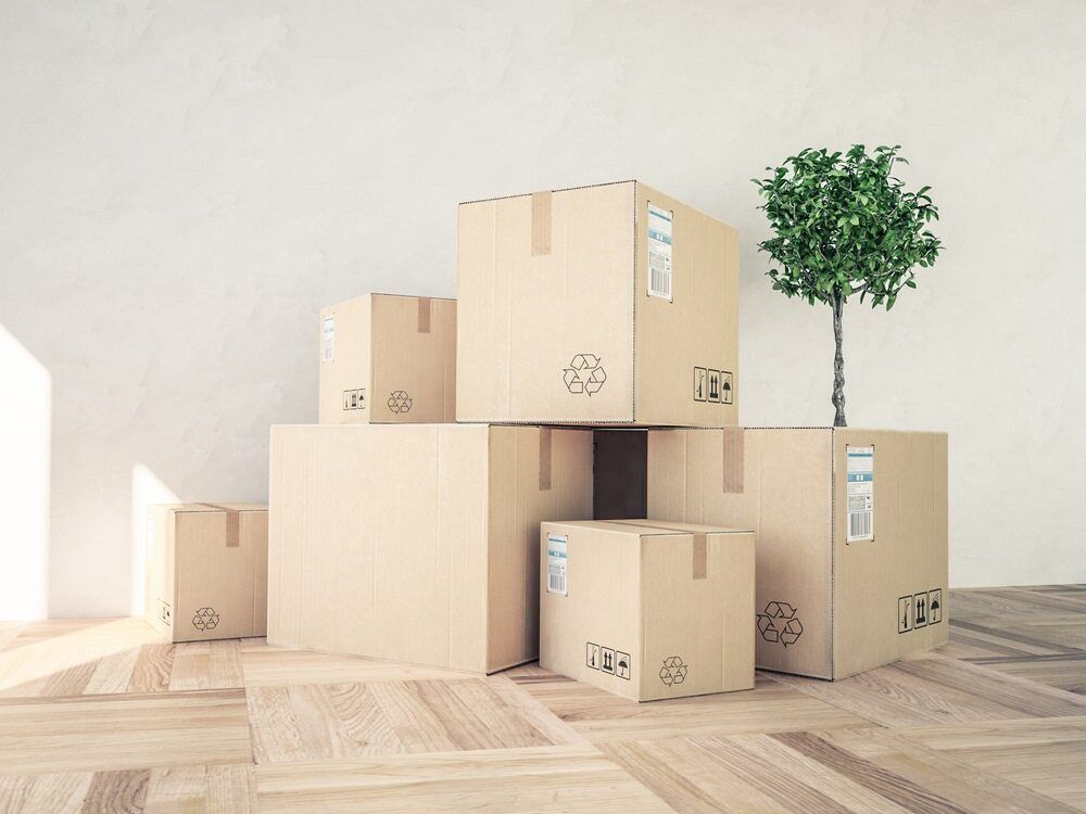 A Bunch Of Cardboard Boxes Are Stacked On Top Of Each Other On A Wooden Floor — Easy Flow Removals In South West Rocks, NSW
