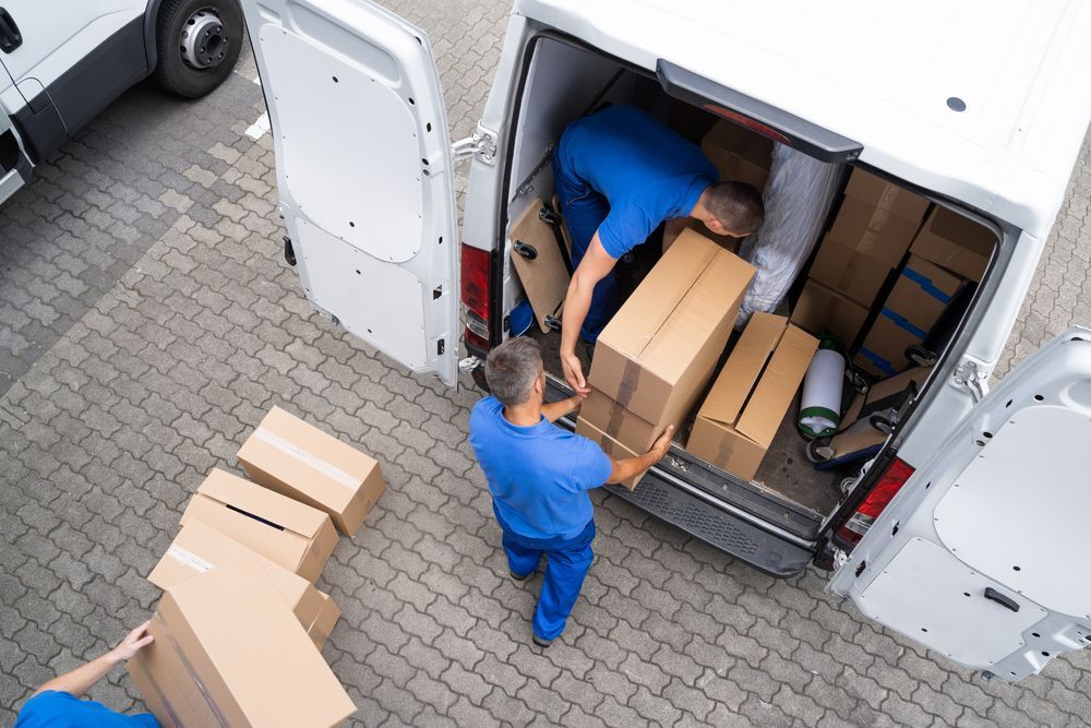 Two Men Are Loading Boxes Into A Delivery Van — Easy Flow Removals In Wauchope, NSW