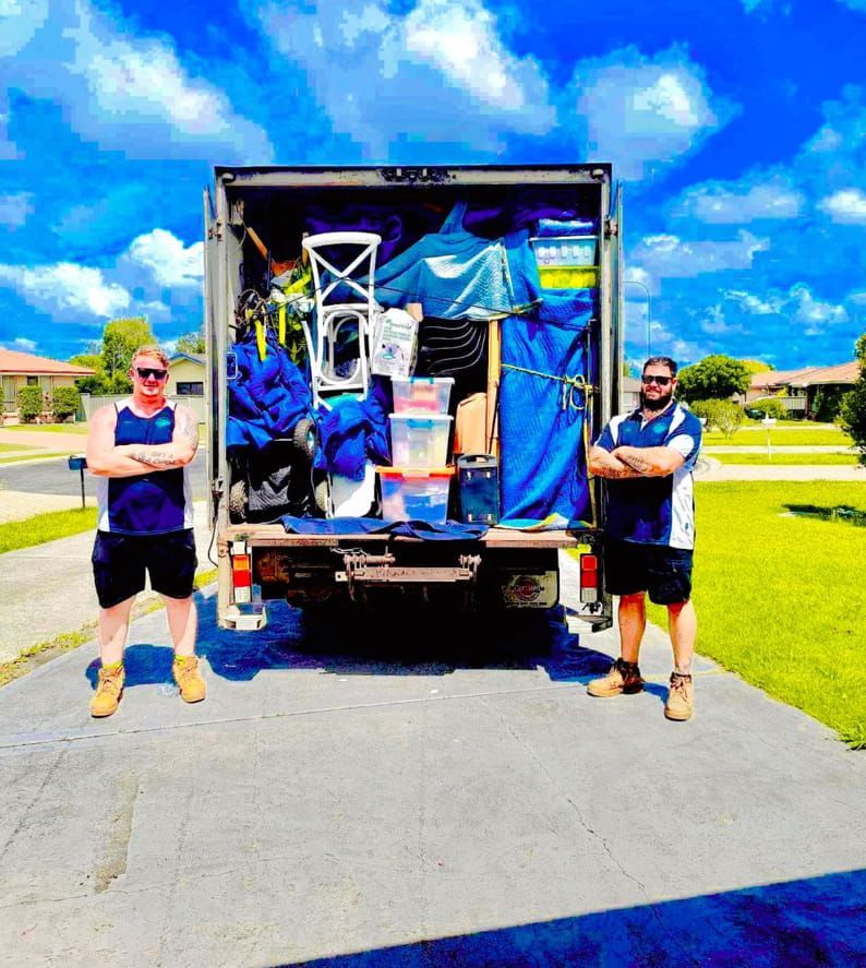 Two Men Are Standing In Front Of A Moving Truck Filled With Furniture — Easy Flow Removals In Wauchope, NSW