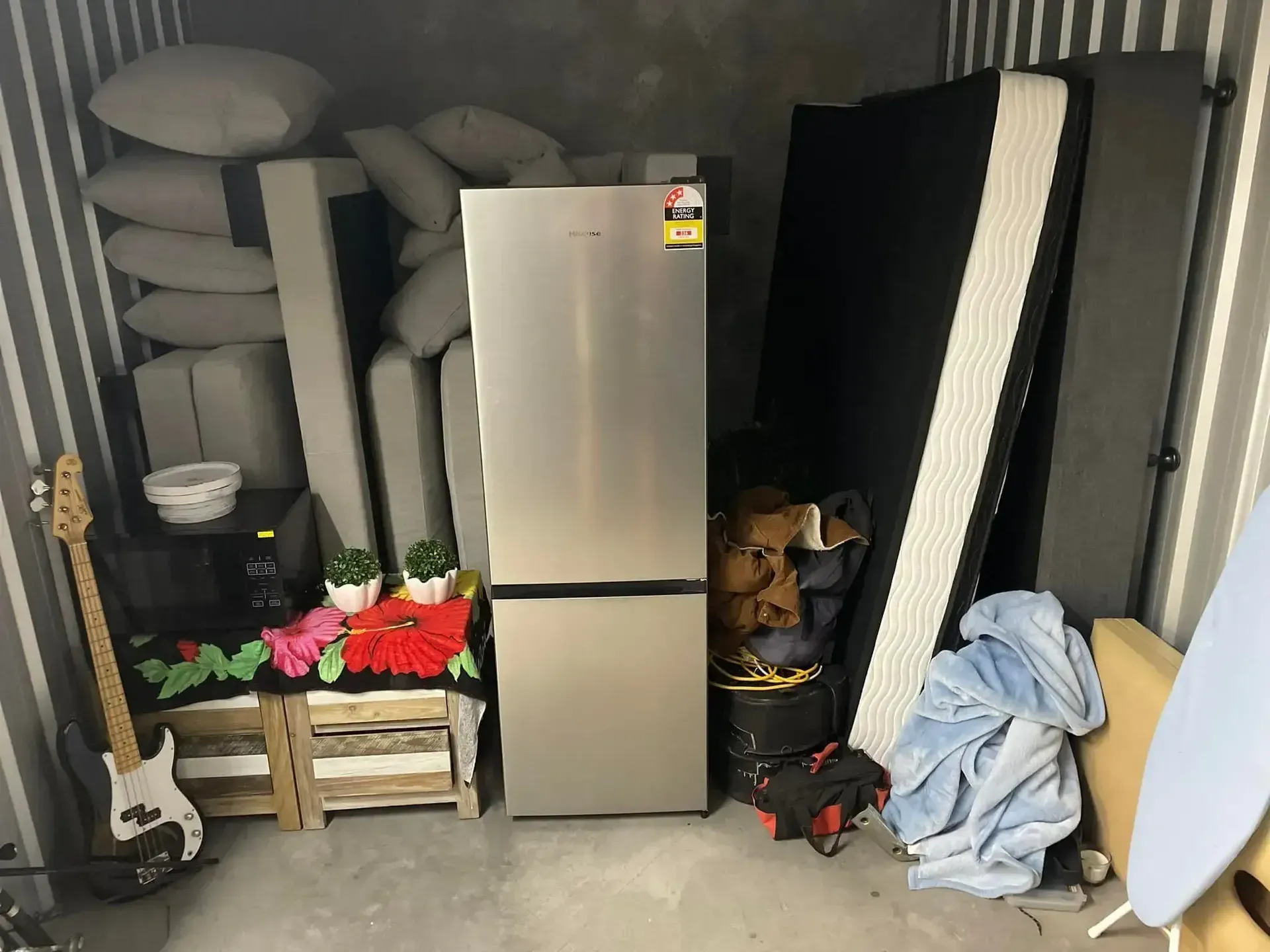 A Stainless Steel Refrigerator Is Sitting In A Room Filled With Furniture And A Guitar — Easy Flow Removals In Wauchope, NSW