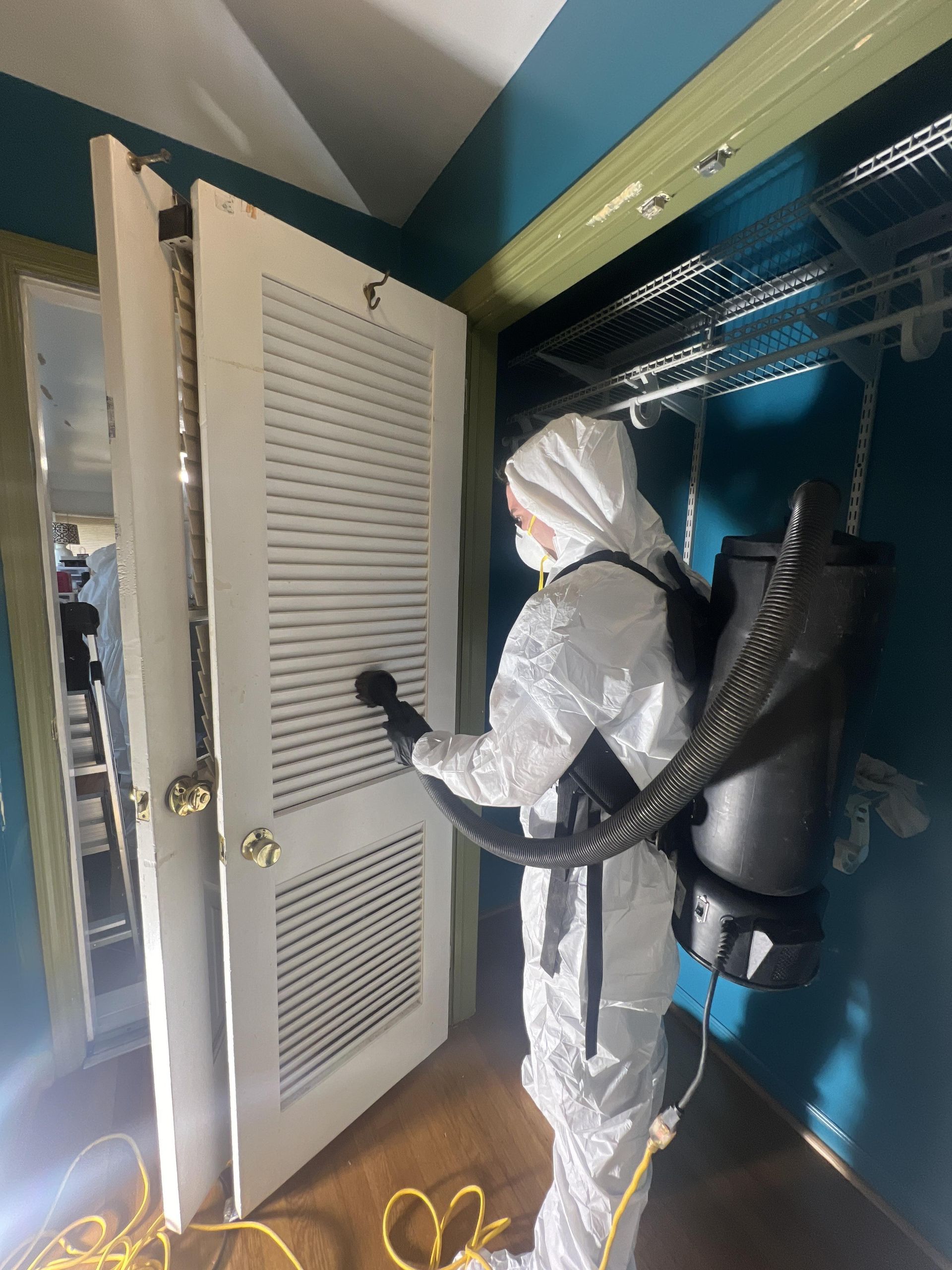 A Zen Dry technician removes smoke residue from a closet door.