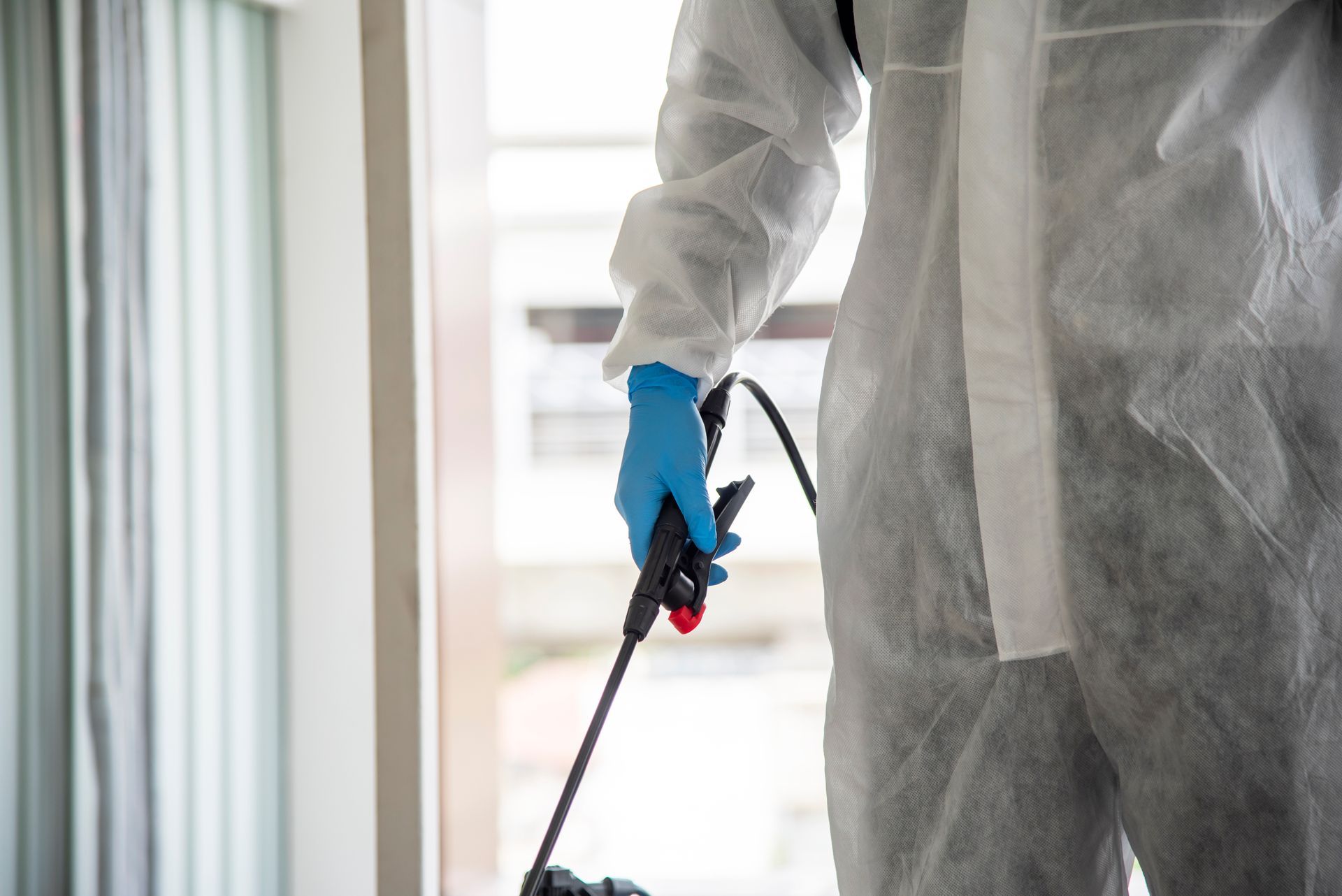 A Zen Dry technician uses protective equipment and treatments to work in a flooded basement.