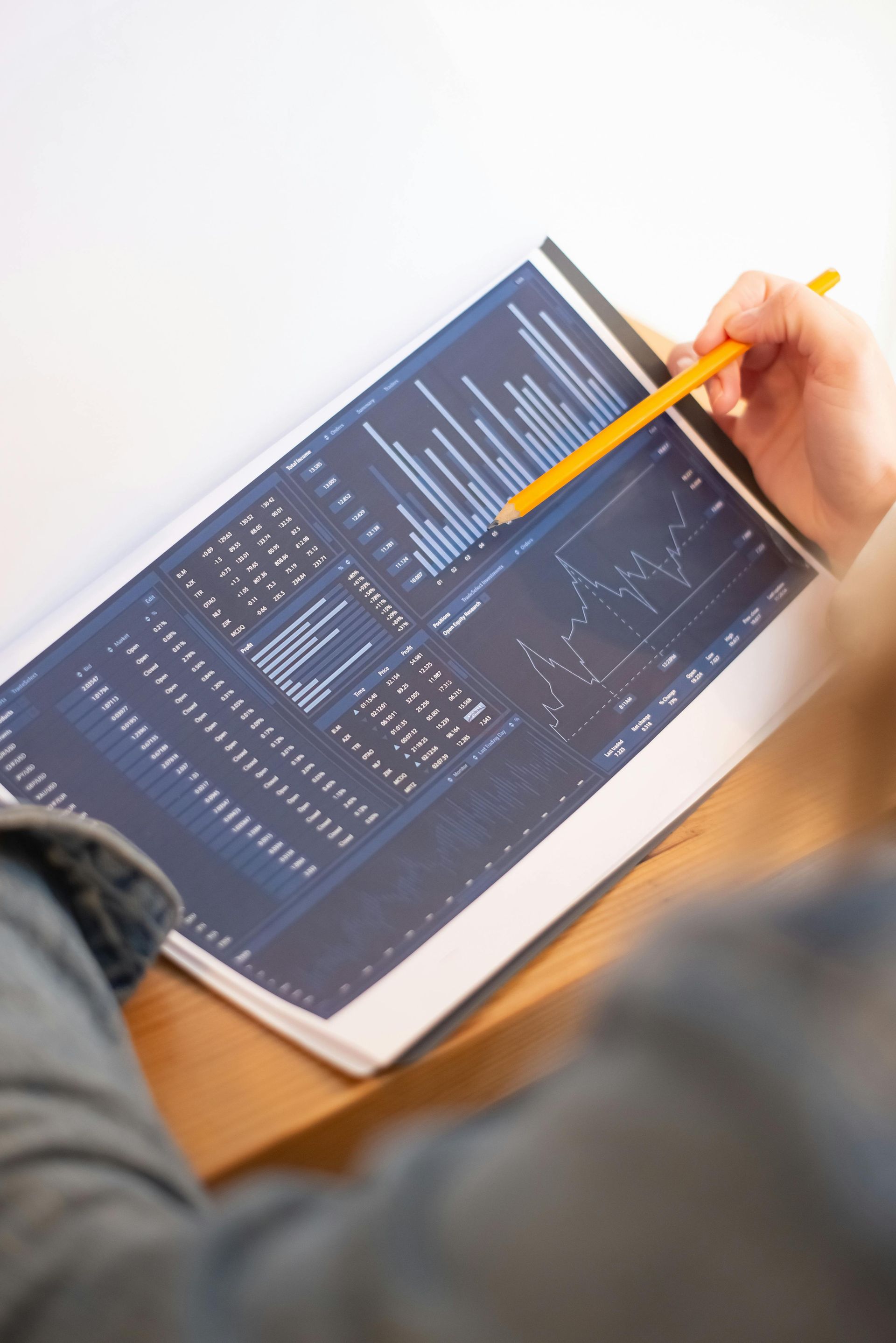 A person is holding a pencil over a piece of paper with a graph on it.