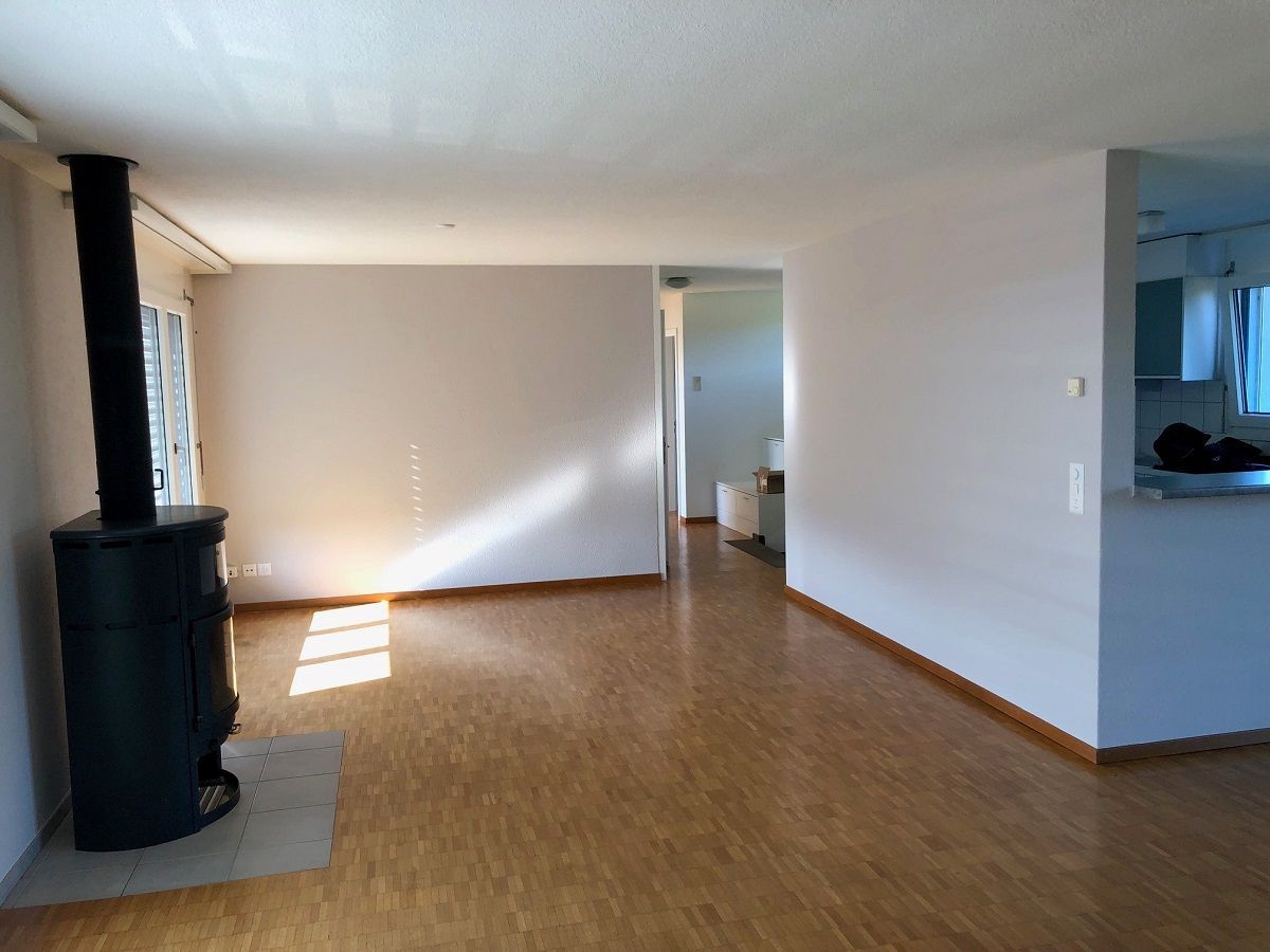 Ein leeres Wohnzimmer mit einem Holzofen in der Mitte