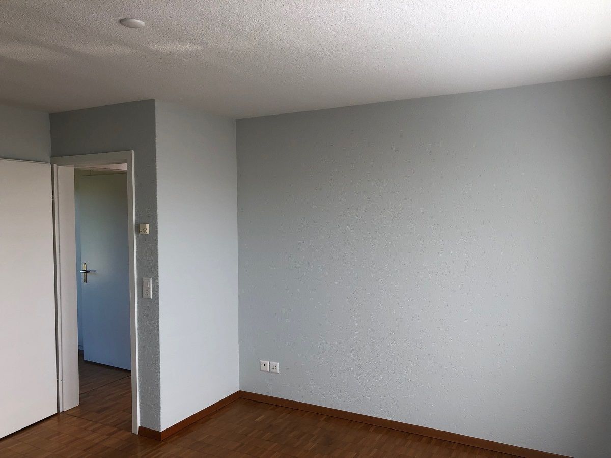 Ein leerer Raum mit einer Tür, die zu einem anderen Raum führt