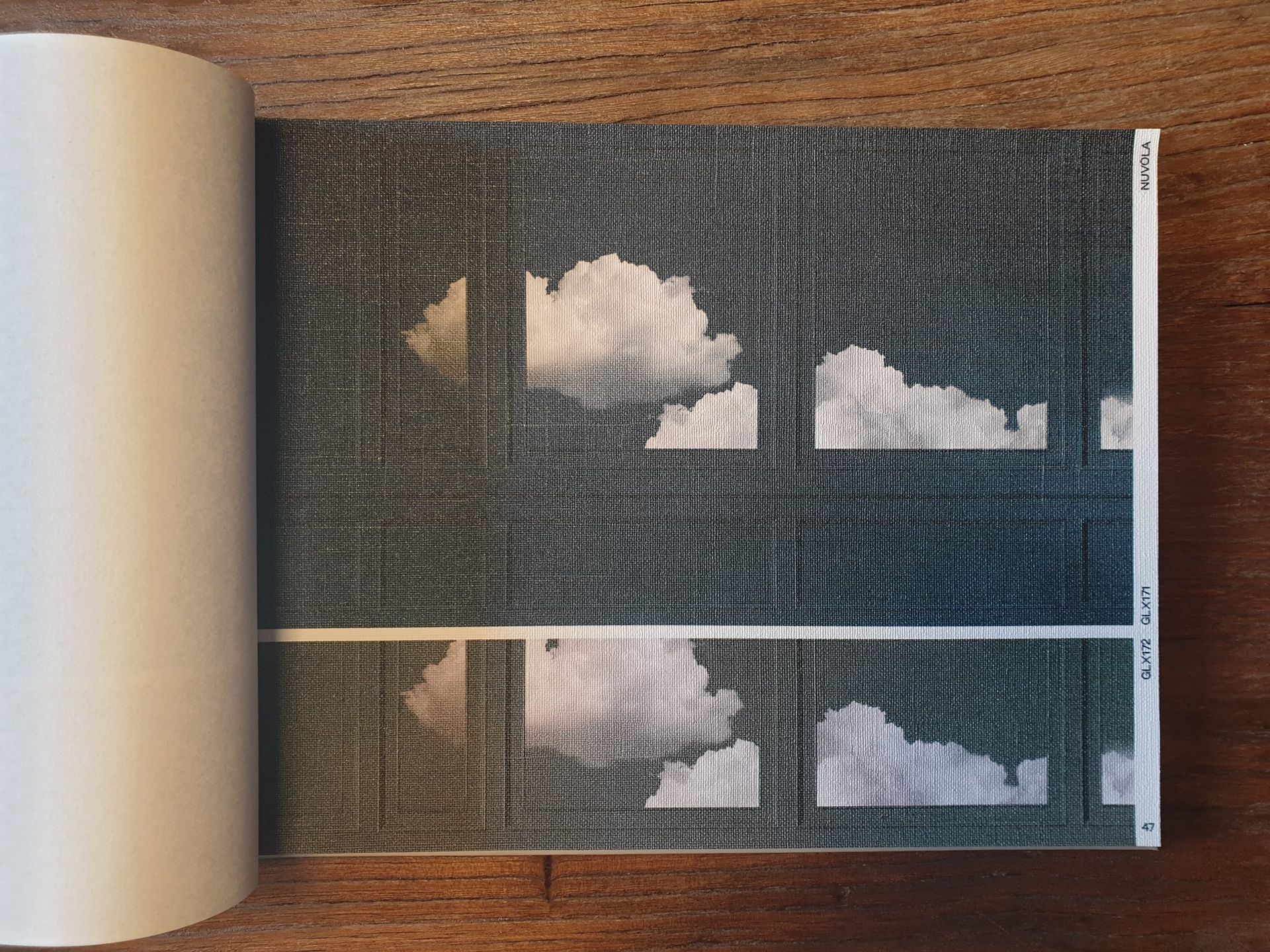 Ein Buch ist auf einer Seite aufgeschlagen, auf der sich ein Bild von Wolken befindet