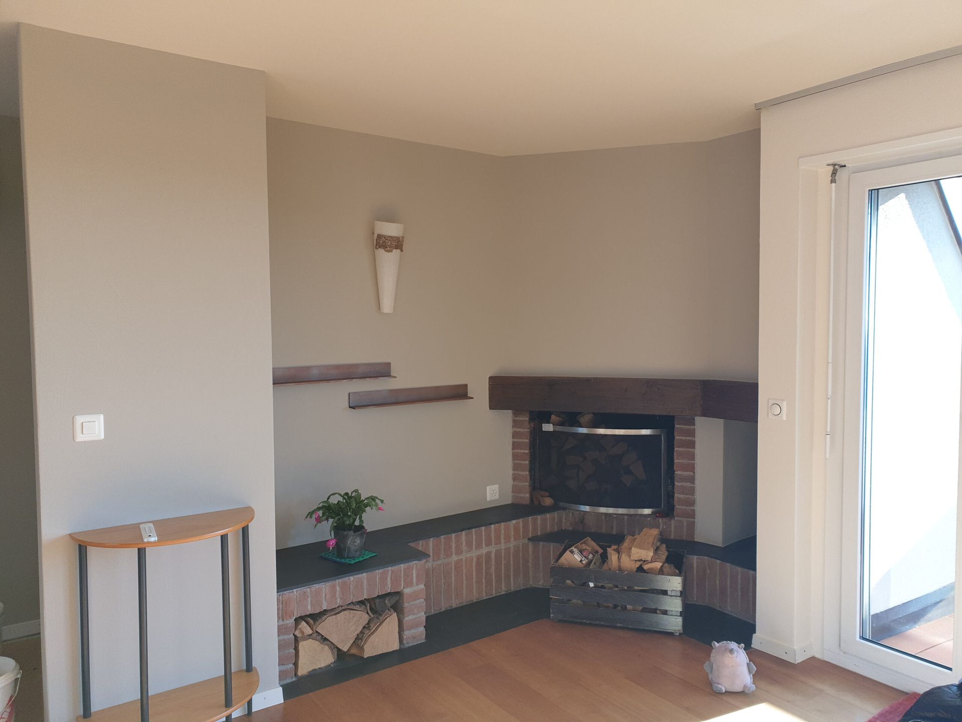 Ein Wohnzimmer mit Kamin und Glasschiebetür.