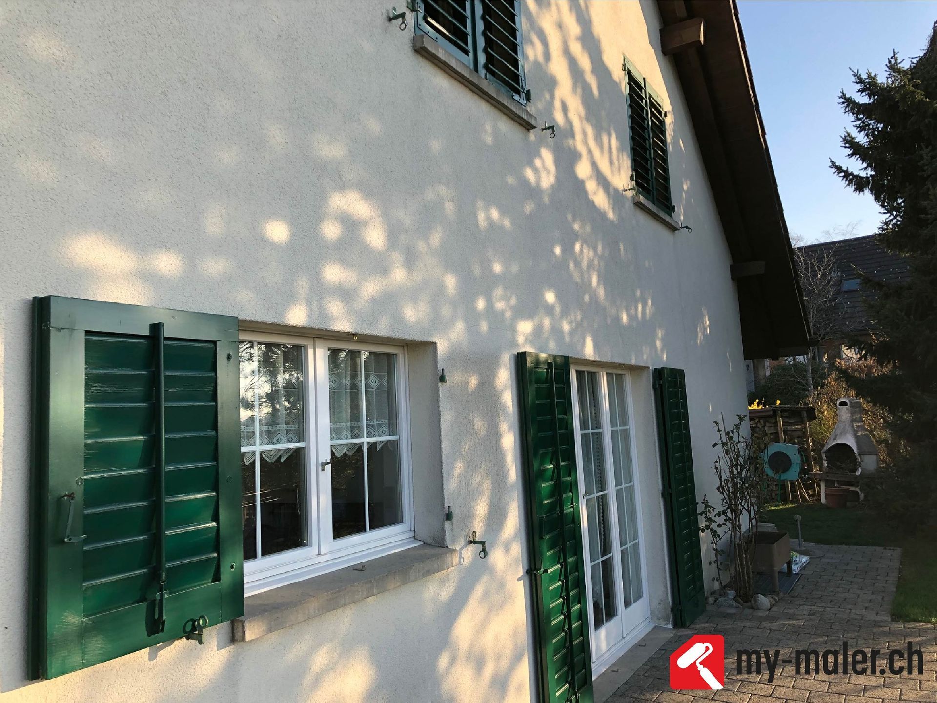 Ein weisses Haus mit grünen Fensterläden