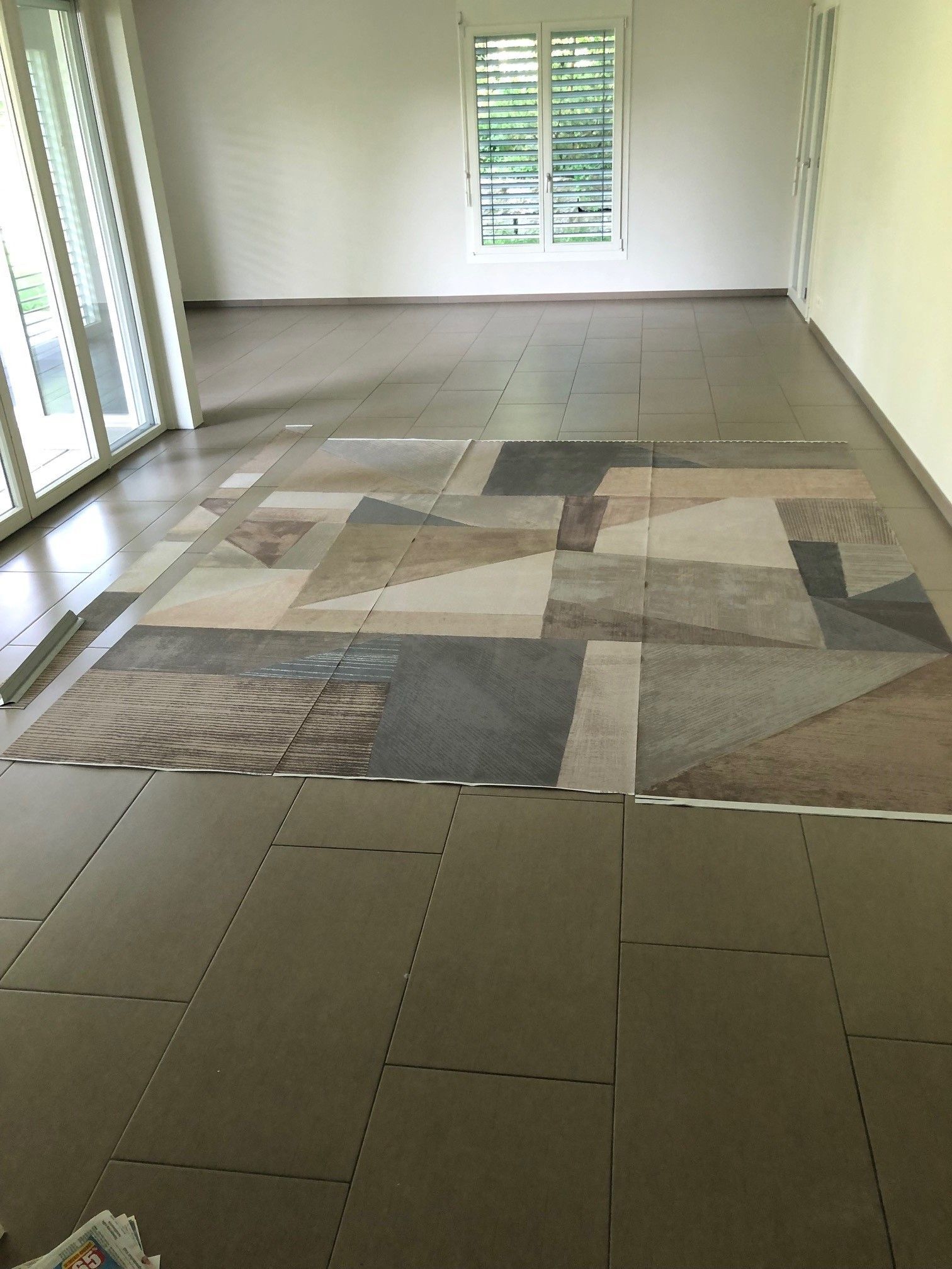 In der Mitte des Zimmers liegt ein Teppich auf dem Boden.