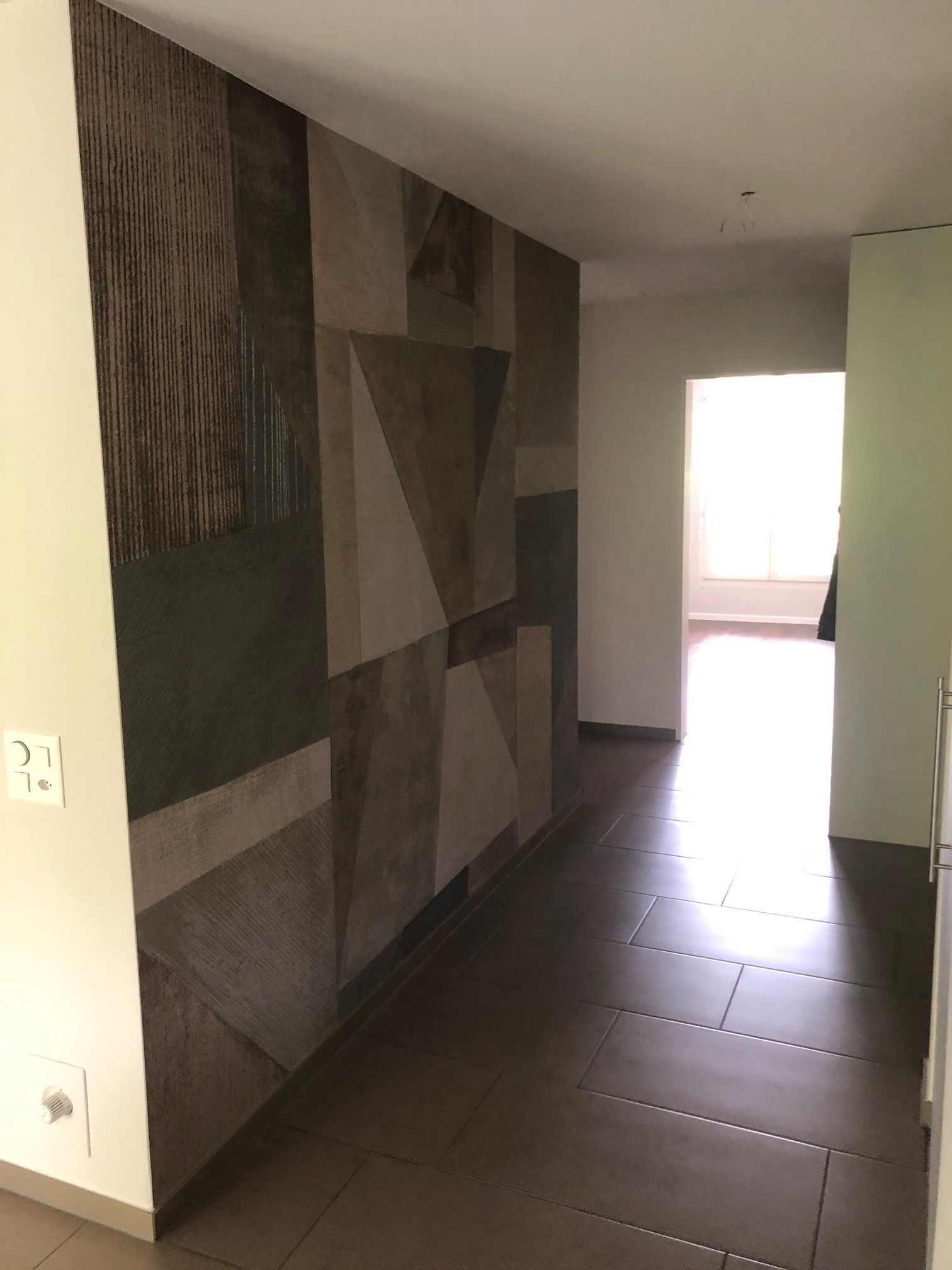 Ein Flur mit einem geometrischen Muster an der Wand.