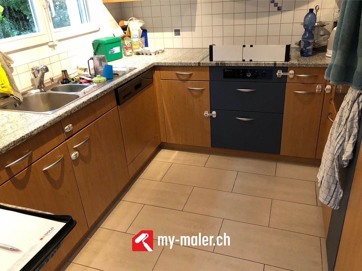 Eine Küche mit Holzschränken und einem blauen Geschirrspüle